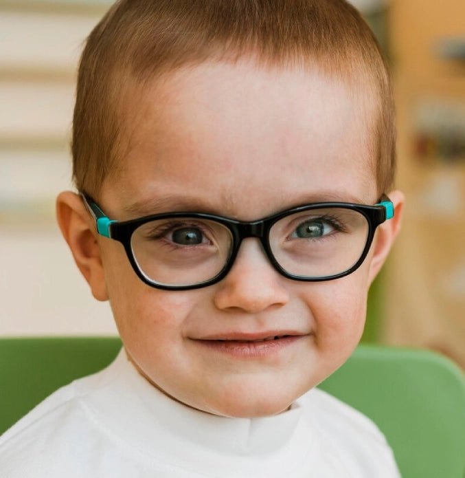 Smiling young child wearing black-and-teal glasses